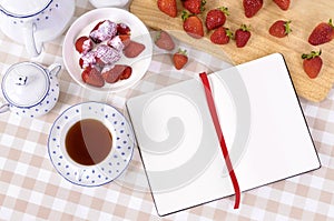 Strawberries cream, bowl, blank recipe book notepad, copy space
