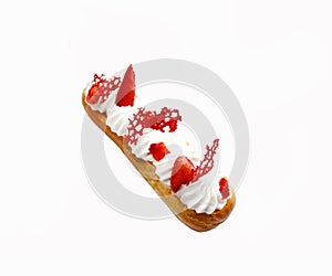 Strawberries and cream eclairs with fresh berries and red lace tuile on white background