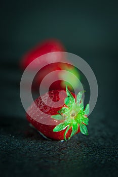 Strawberries on dark background with water drops