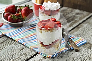 Strawberries dessert with biscuit and cream served on glasses