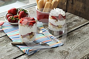 Strawberries dessert with biscuit and cream served on glasses