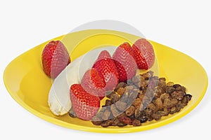 Strawberries Dry Grapes And Banana On Yellow Plate