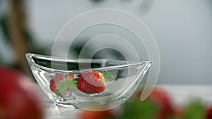 Strawberries fall into the glass cup