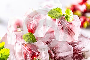 Strawberries frozen in ice cubes with mellisa leaves