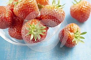 Strawberries in a glass bowl on a blue table