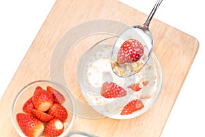 Strawberries in a glass bowl with cereal, on the table