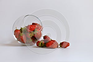 Strawberries in a glass vase on a white background.