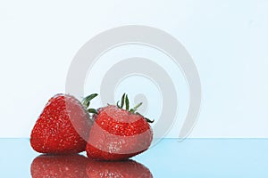 Strawberries isolated. Strawberry with leaf isolate. Two whole strawberries on white and blue. Side view