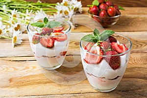 Strawberries layered cream cheese dessert on wooden background