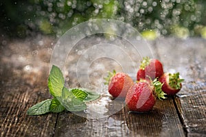 Strawberries in the rain on a wooden table close-up