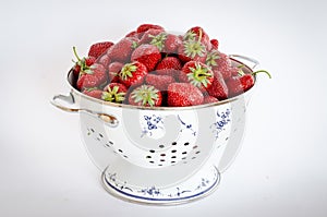 Strawberries in a round strainer.