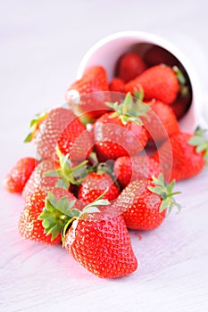 Strawberries spilling from a cup