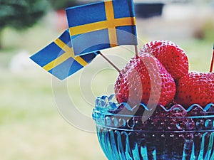 Strawberries with Swedish flags. Celebration of Swedens National Day or Midsummer.