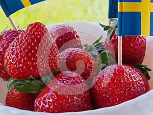 Strawberries and Swedish flags for celebration of Swedens National Day or Midsummer.