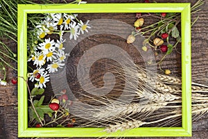 Strawberries, wheat and chamomile in a green frame.