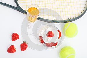 Strawberries with whipped cream, glasses with champagne and  tennis equipment on Wimbledon tournament