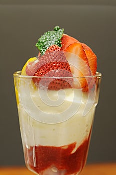 Strawberries yoghurt in glass gray background,