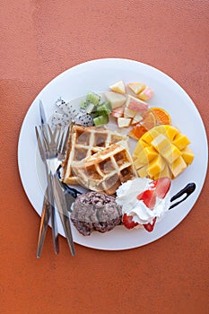 strawberry apple mango orange kiwi waffle with chocolate ice cream and whip cream