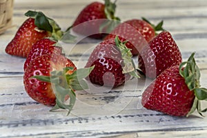 Strawberry in basket and on table on wooden background