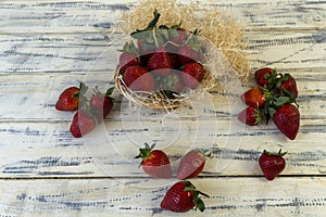 Strawberry in basket and on table on wooden background