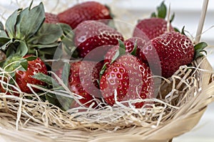 Strawberry in basket and on table on wooden background