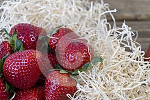 Strawberry in basket and on table on wooden background