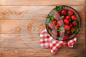 Strawberry berry. Fresh red strawberry in ceramic rustic plate in basket on light wooden rustic table, closeup. Delicious, juicy,