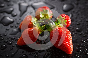 Strawberry on a black background with water