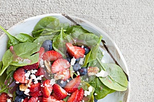 Strawberry blueberry walnut spinach salad close up top view
