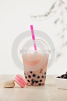 Strawberry Boba Bubble Tea with macaron and ice.