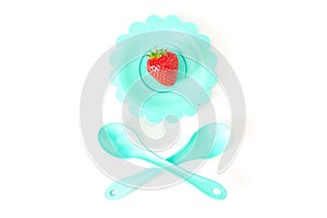 Strawberry on a bright saucer isolated white