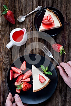 Strawberry cheesecake on rustic wooden table.