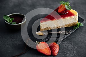 Strawberry cheesecake slice close up on a dark