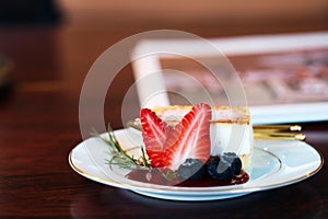 strawberry cheesecake on white dish in cafe