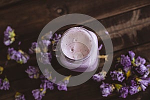 Strawberry and cranberry smoothie with dried flowers on a wooden table