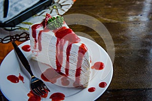 strawberry crape cake on wood table in coffee shop , dessert tasy cake