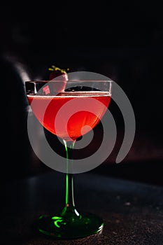 Strawberry daiquiri cocktail in a glass from above with a strawberry decoration