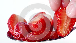 Strawberry dessert on moving spoon. Fingers by female hand decoration