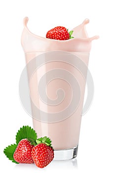 strawberry falling in glass of milkshake with splash