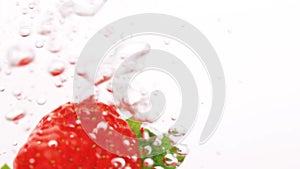 Strawberry falling into the water with bubbles on white background. Fresh berries in the water. Organic berry, fruit