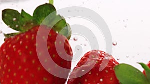 Strawberry falling into the water with bubbles on white background. Fresh berries in the water. Organic berry, fruit