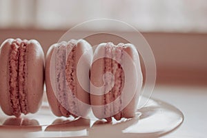 Strawberry french macarons closeup. Fresh and colourful on pink background