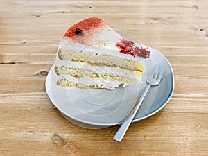 A strawberry frozen yogurt cake in a plate on wooden table.