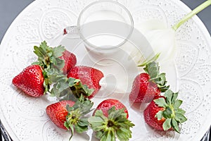 Strawberry and glass of milk on white plate