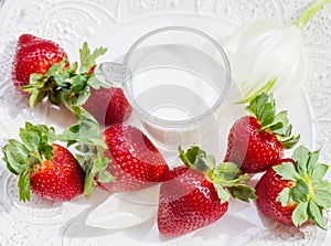 Strawberry and glass of milk on white plate