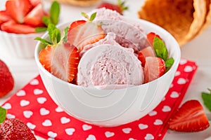 Strawberry ice cream with fresh berries in a bowl on a white wooden background. Selective focus