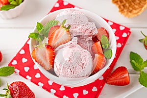 Strawberry ice cream with fresh berries in a bowl on a white wooden background. Selective focus