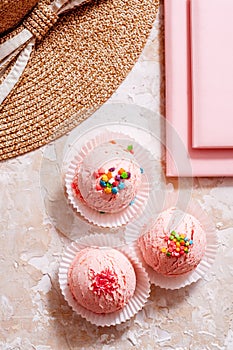 strawberry ice cream on a light background, the concept of summer, straw hat, pink notebook