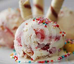 Strawberry ice cream with mango and wafer rolls close up