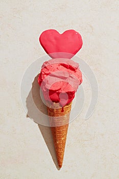 Strawberry ice cream with waffle cone melting on the ground in love heart shape